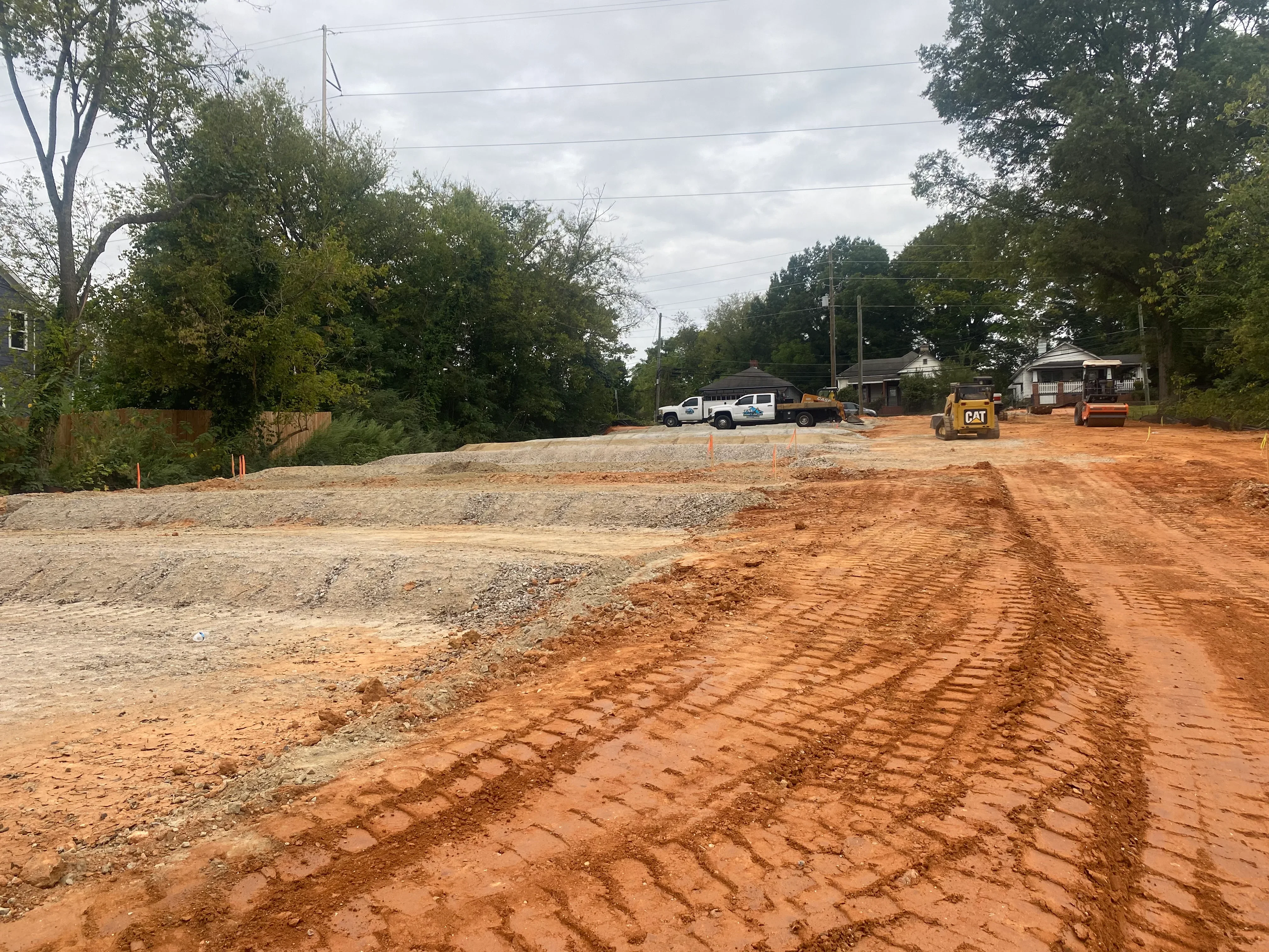 Excavated residential lot with graded clay base, compacted fill, and heavy equipment on site