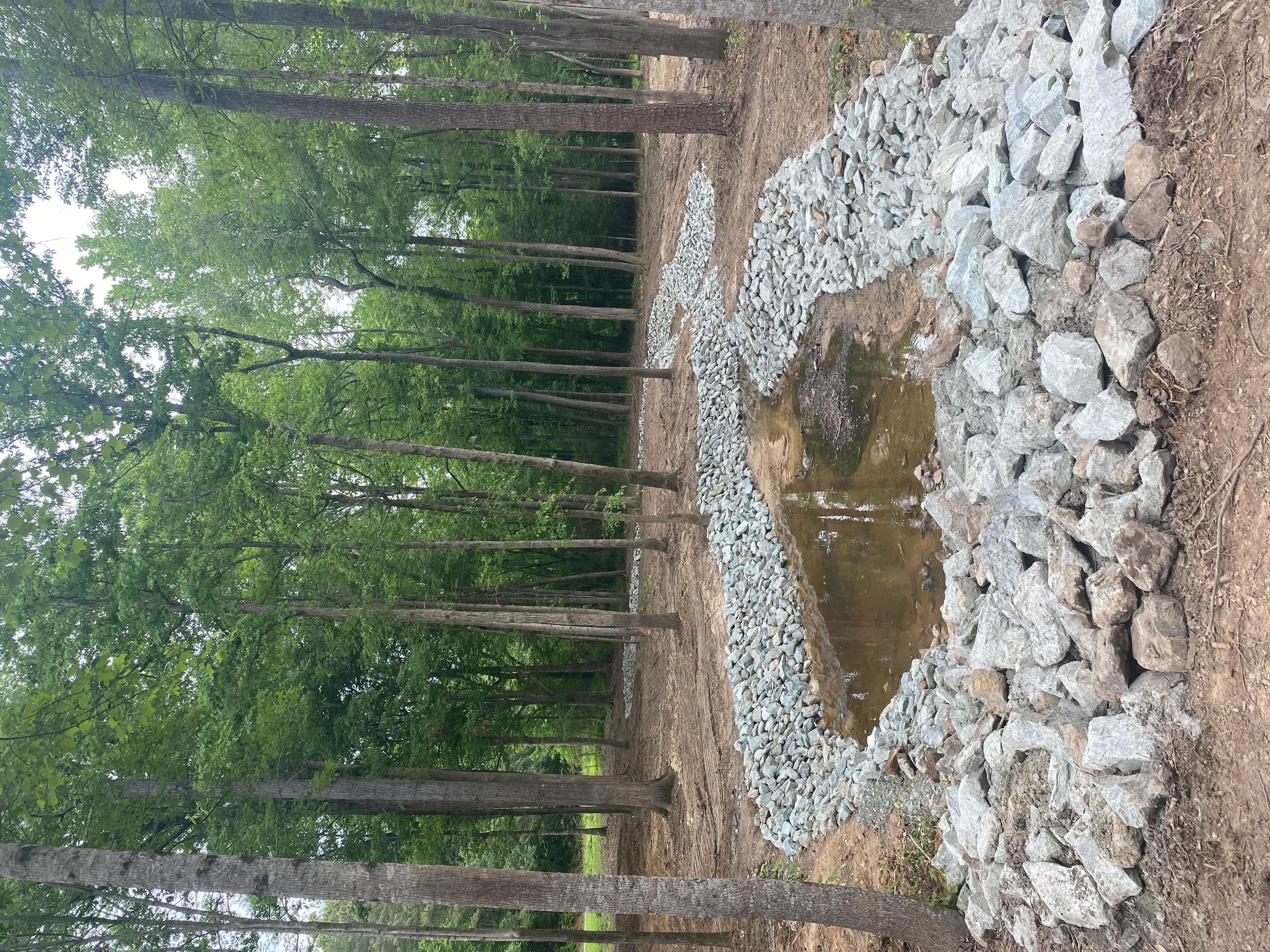 Driveway excavation with white gravel base and drainage preparation