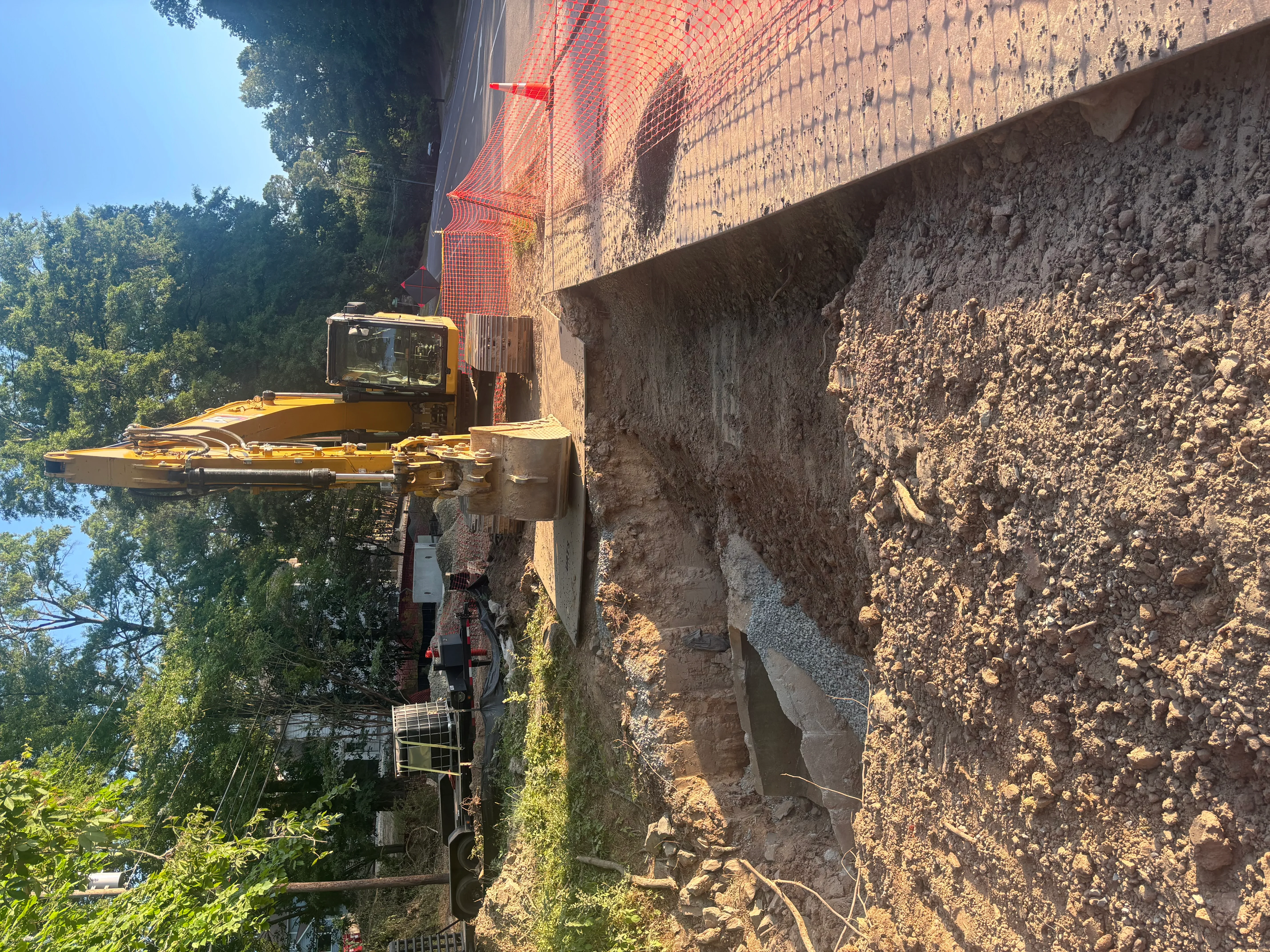 Excavator on tracked carrier removing soil and earth from residential building site