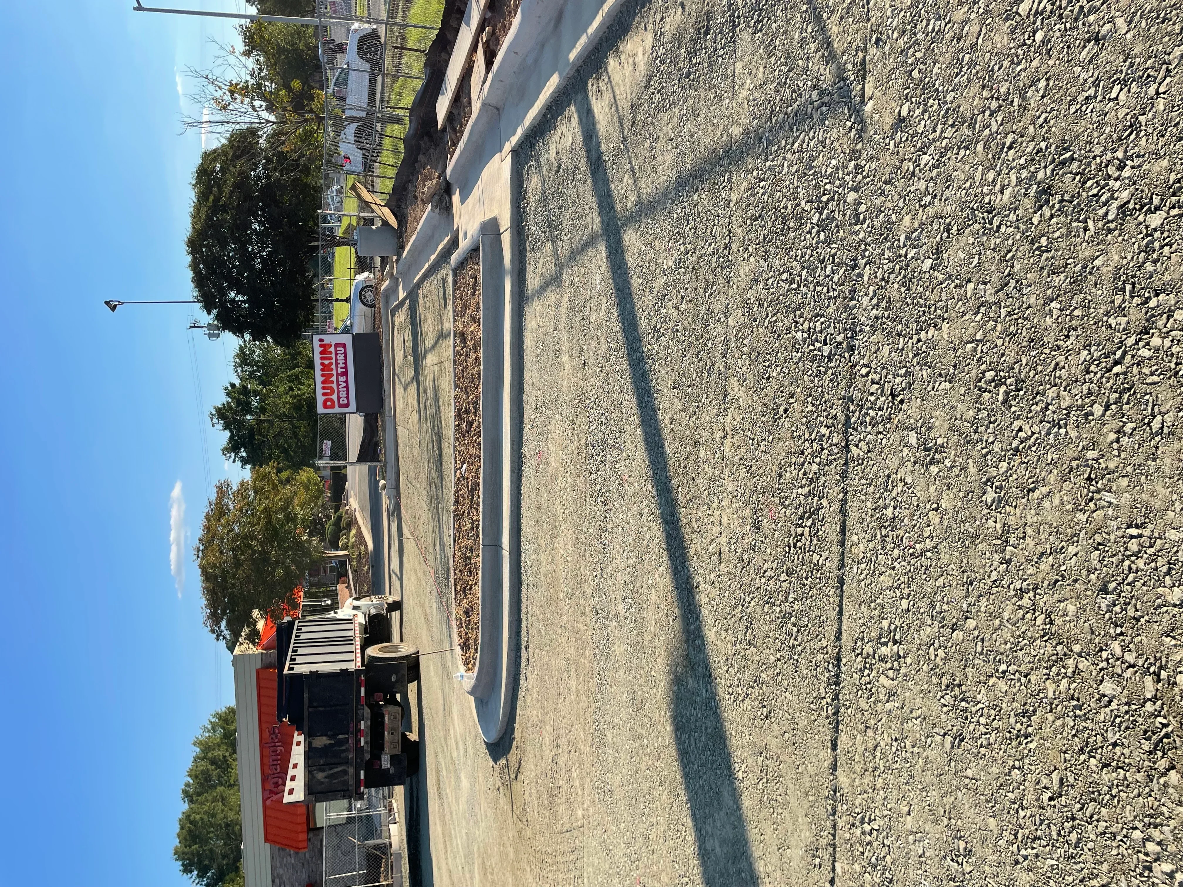 Excavated driveway with compacted gravel base and grading work in progress